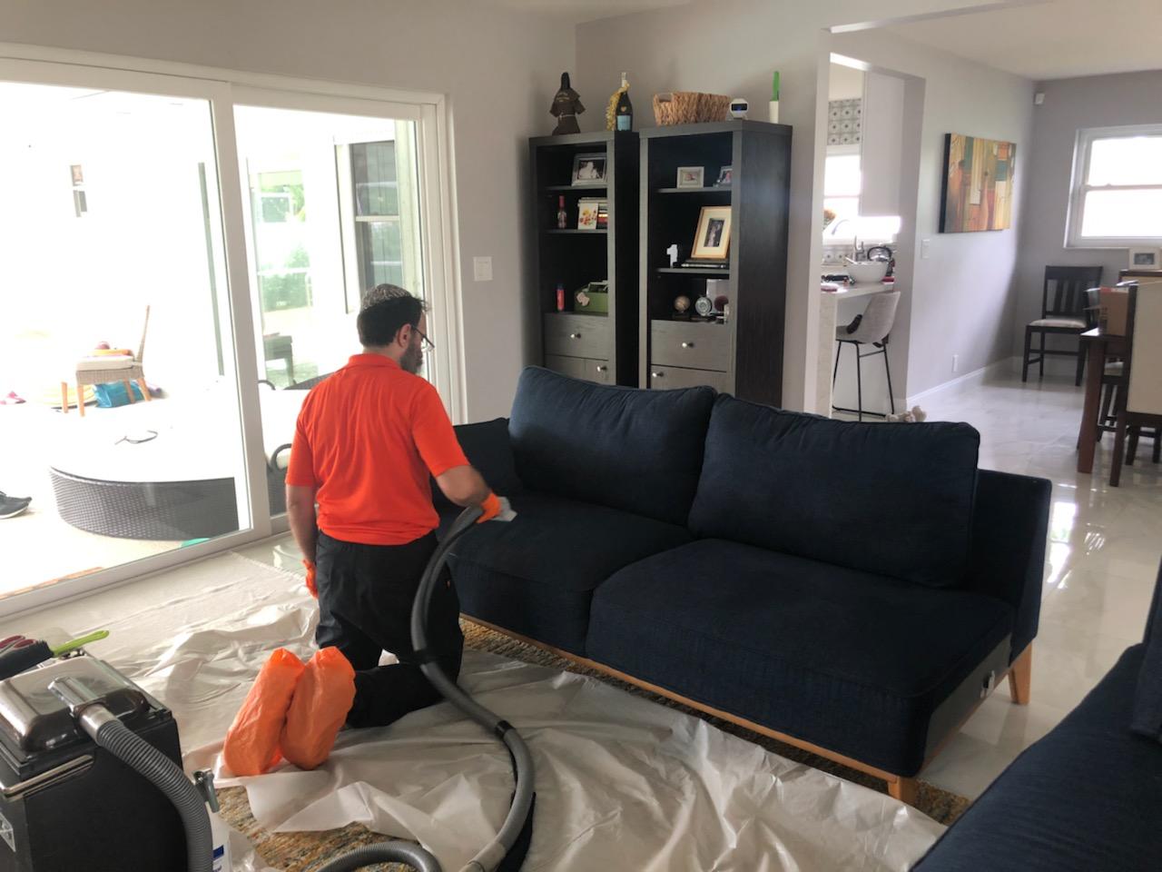 Rugsies team member cleaning a customer's couch in their home